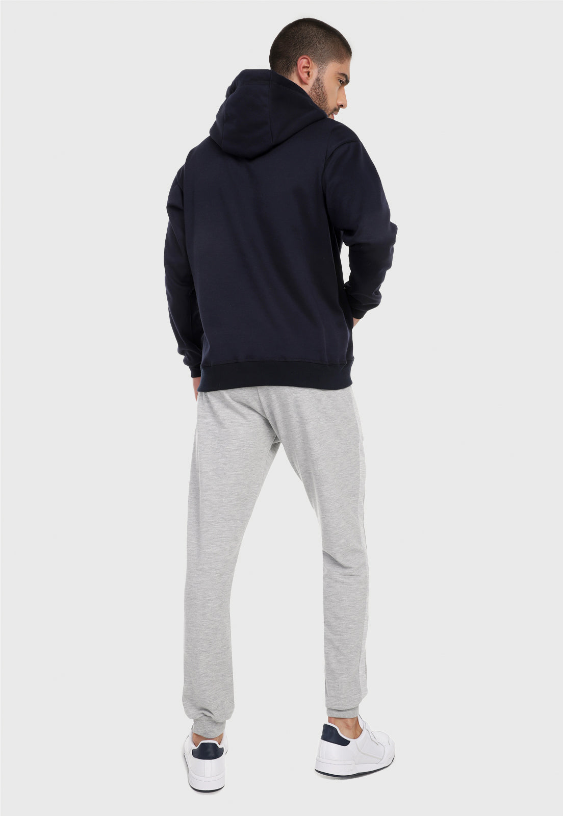 Hombre adulto visto de espalda vistiendo la sudadera para hombre conjunto buzo azul con pantalón de sudadera gris jaspe Arctic Fox.