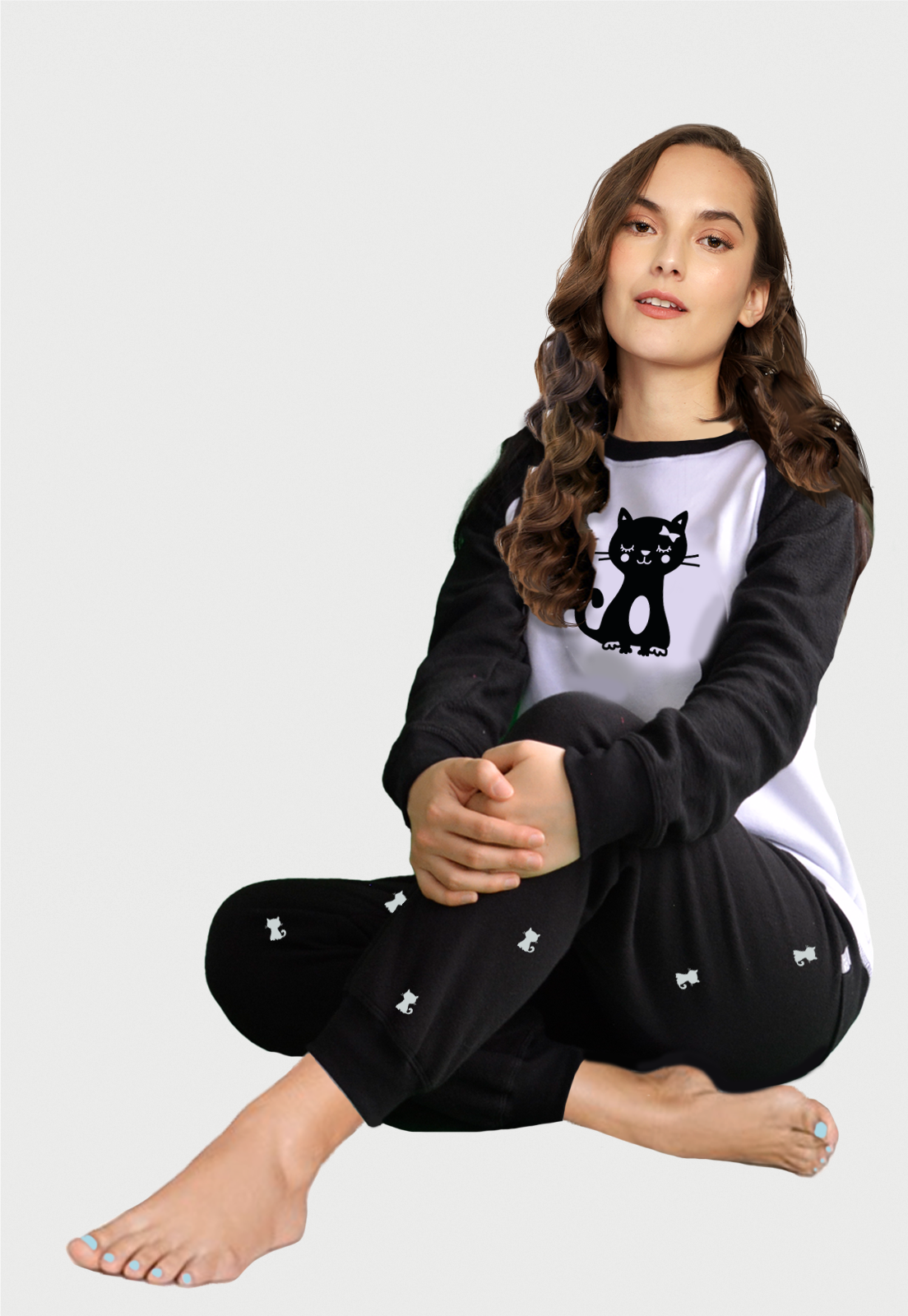 una mujer sentada usanddo una pijama de saco y pantalon negro con un gato estampaddo