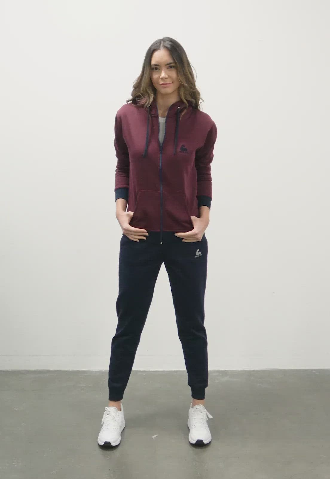 mujer luciendo una sudadera vinotinto con cremallera el pantalon es azul