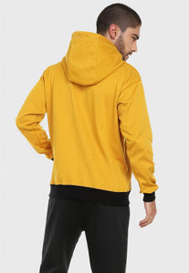 Hombre visto de espalda vistiendo el buzo hoodie mostaza para hombre Arctic Fox.