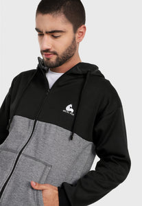 Detalle en buzo de hombre adulto vistiendo la sudadera para hombre conjunto chaqueta hoodie Negro y Gris con pantalón de sudadera negro y corte gris.