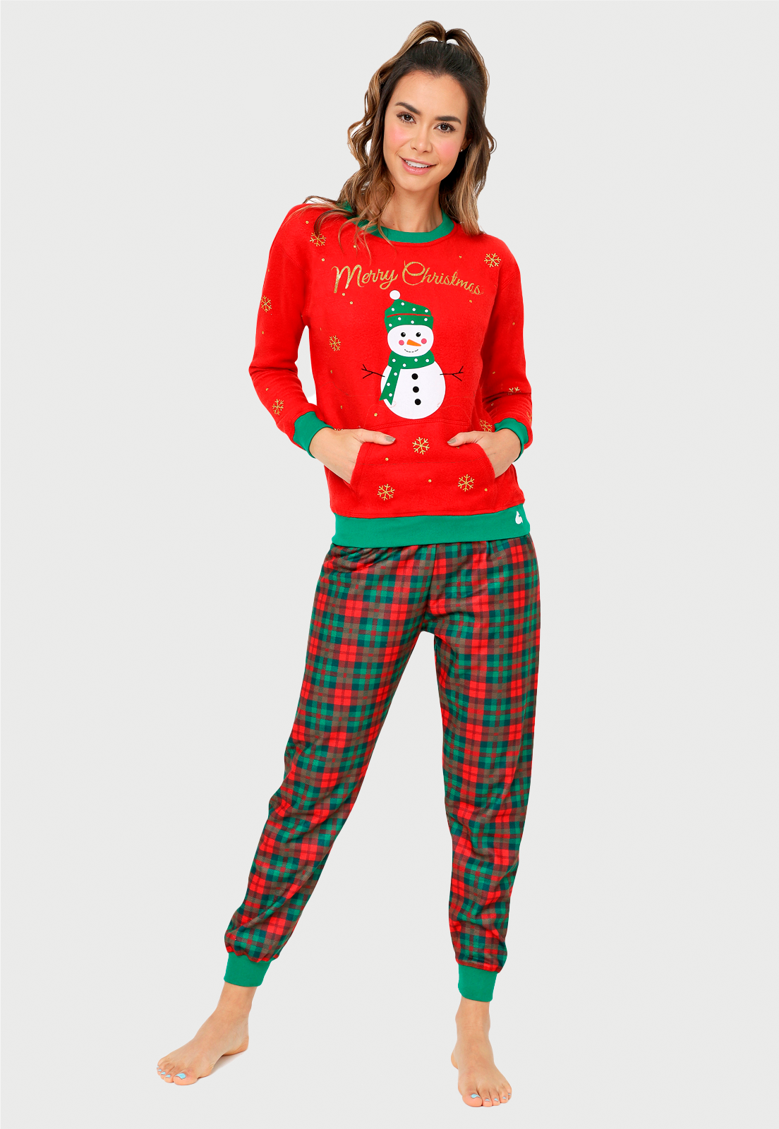 Linda mujer usando una pijama de navidad de pantalón escoses y saco rojo estampado con un muñeco de nieve 