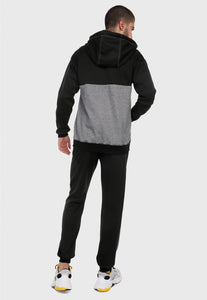 Hombre adulto visto de espalda vistiendo la sudadera para hombre conjunto chaqueta hoodie Negro y Gris con pantalón de sudadera negro y corte gris.