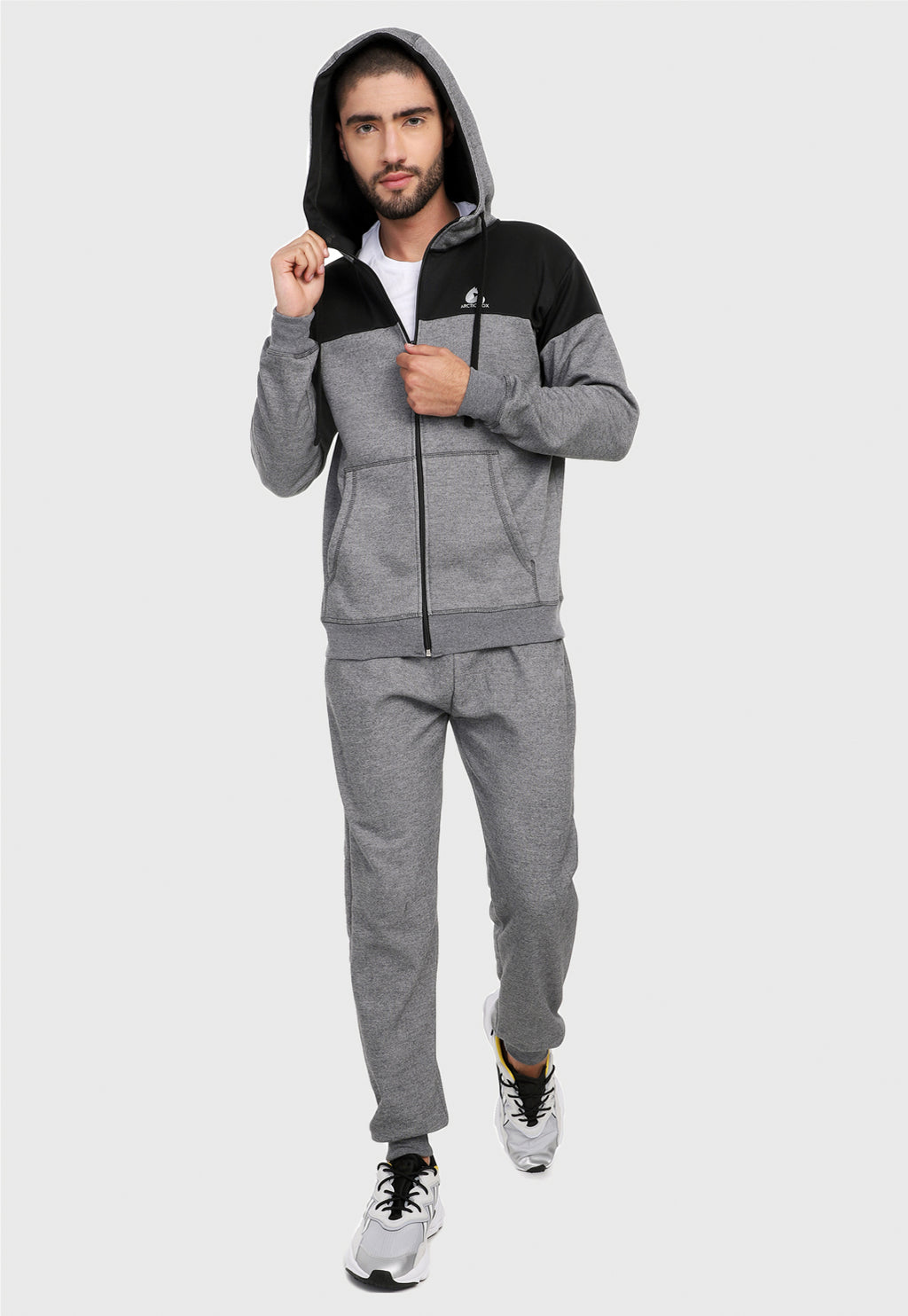 Hombre adulto vistiendo la sudadera para hombre conjunto chaqueta hoodie Gris y Negra corte americano con pantalón de sudadera gris.