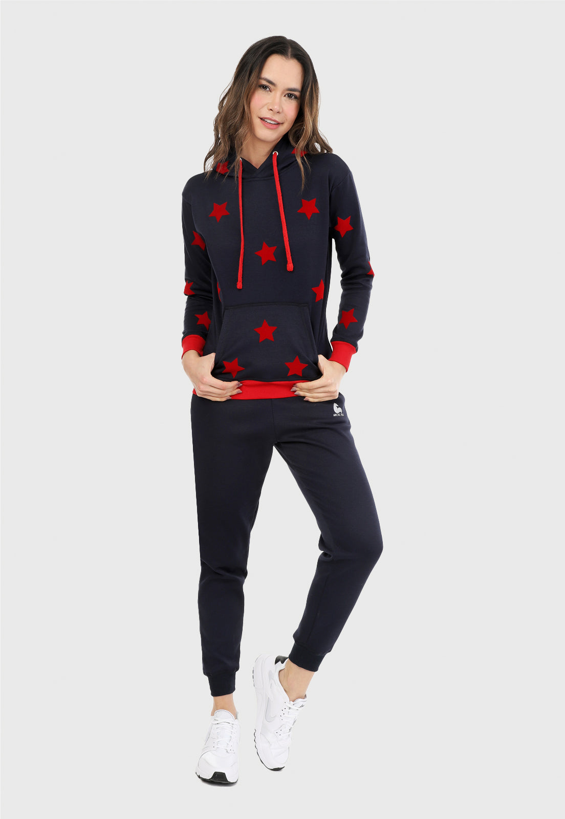 Mujer vistiendo la sudadera para mujer conjunto buzo hoodie color azul con estrellas rojas y pantalón de sudadera negro.