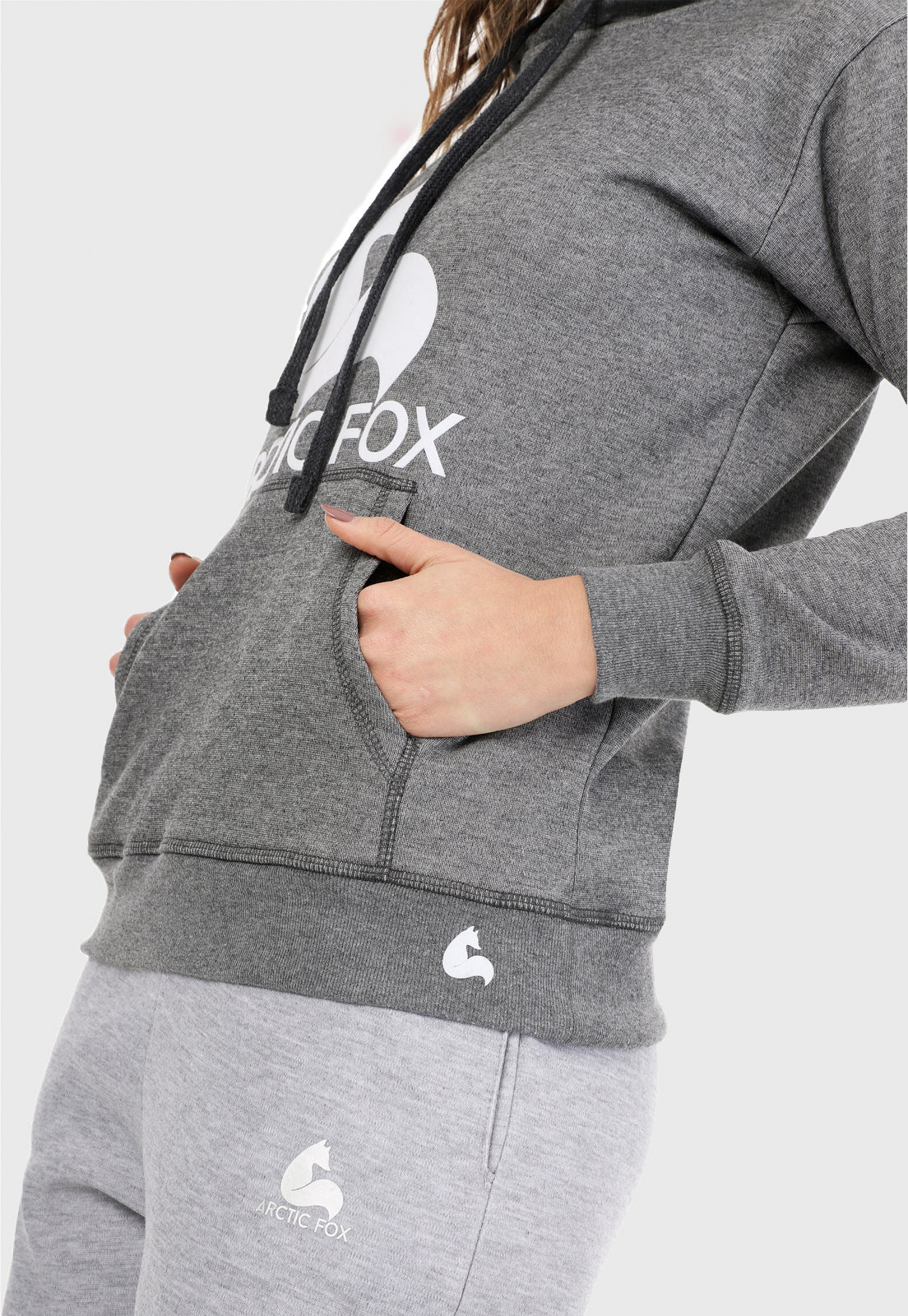 Detalle de Mujer vistiendo la sudadera para mujer conjunto buzo hoodie gris obscuro y pantalón de sudadera jaspe.