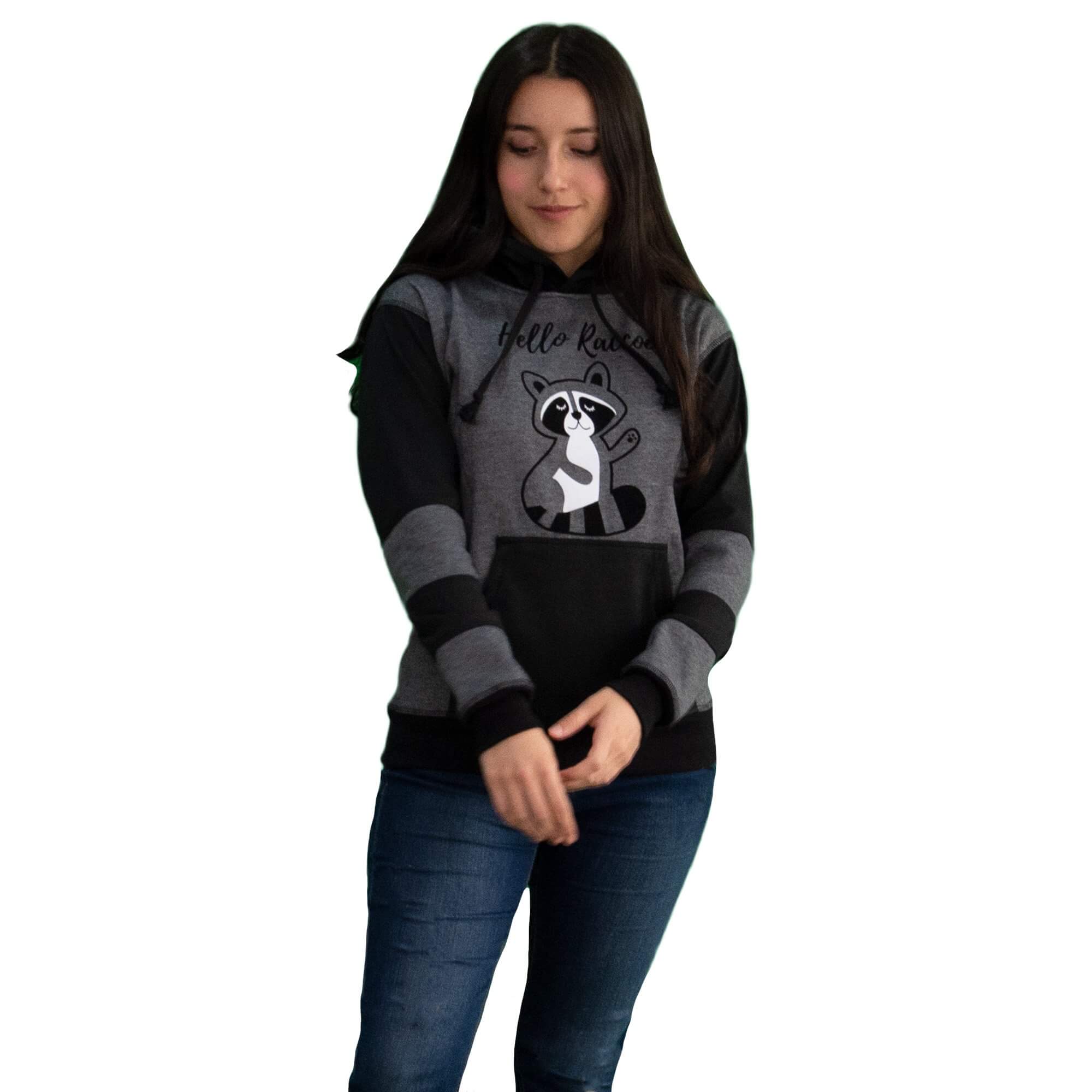 Niña vistiendo el Buzo Hoodie Gris y Negro con Mapache estampado en el pecho y franjas negras en las mangas.
