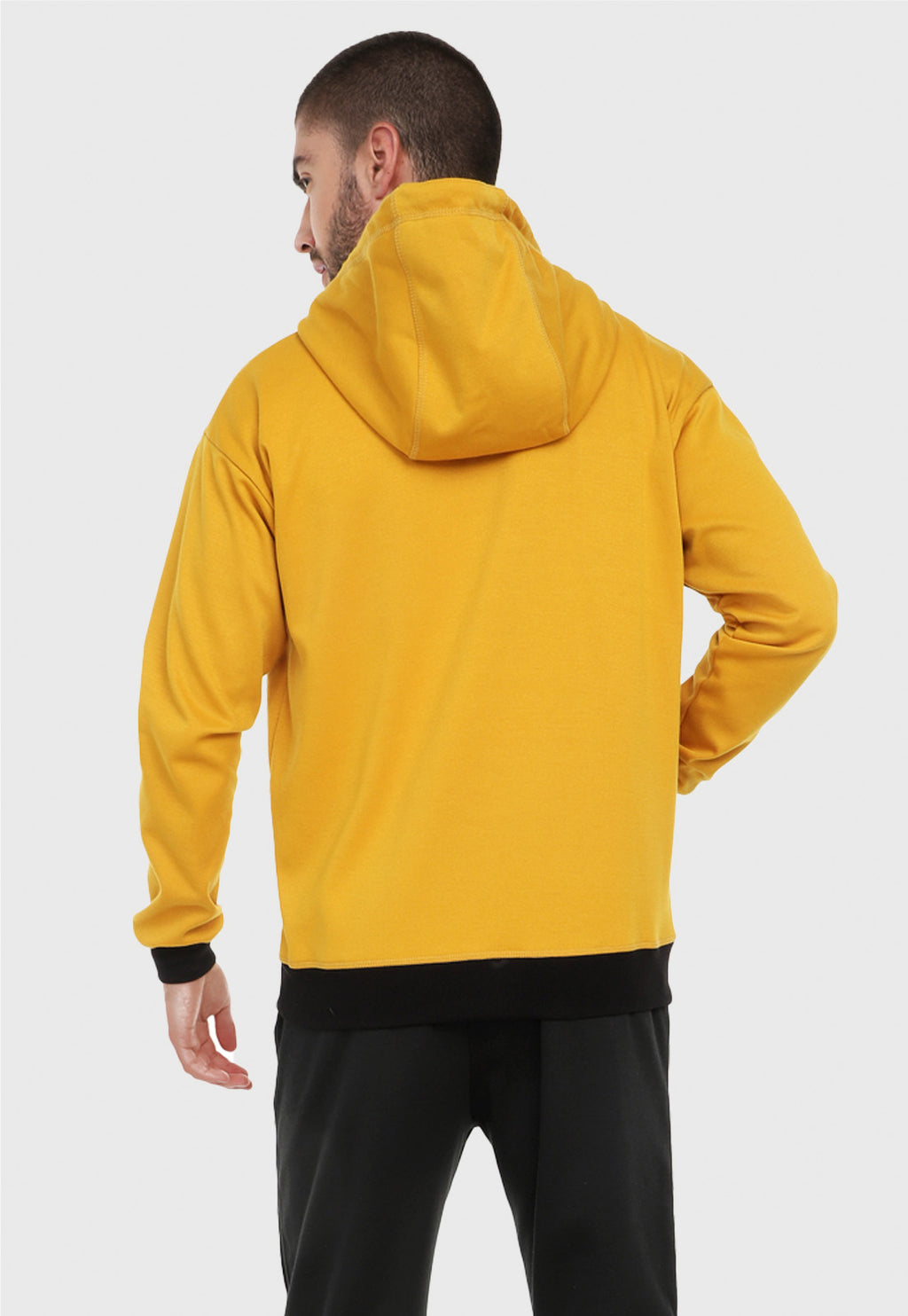 Hombre visto de espalda vistiendo la chaqueta hoodie mostaza para hombre con capota forrada al interior negra.