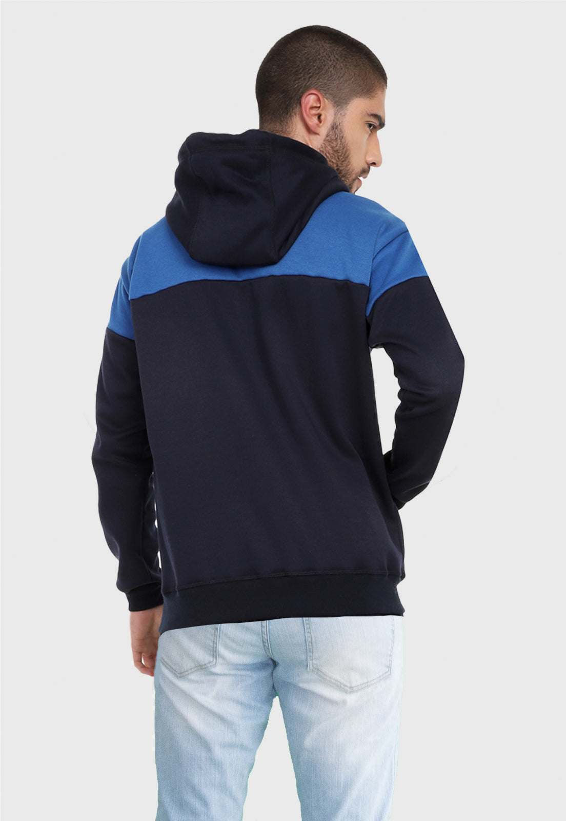 Hombre de espalda vistiendo la chaqueta hoodie azul oscuro y azul rey para hombre corte americano con capota forrada en azul rey.