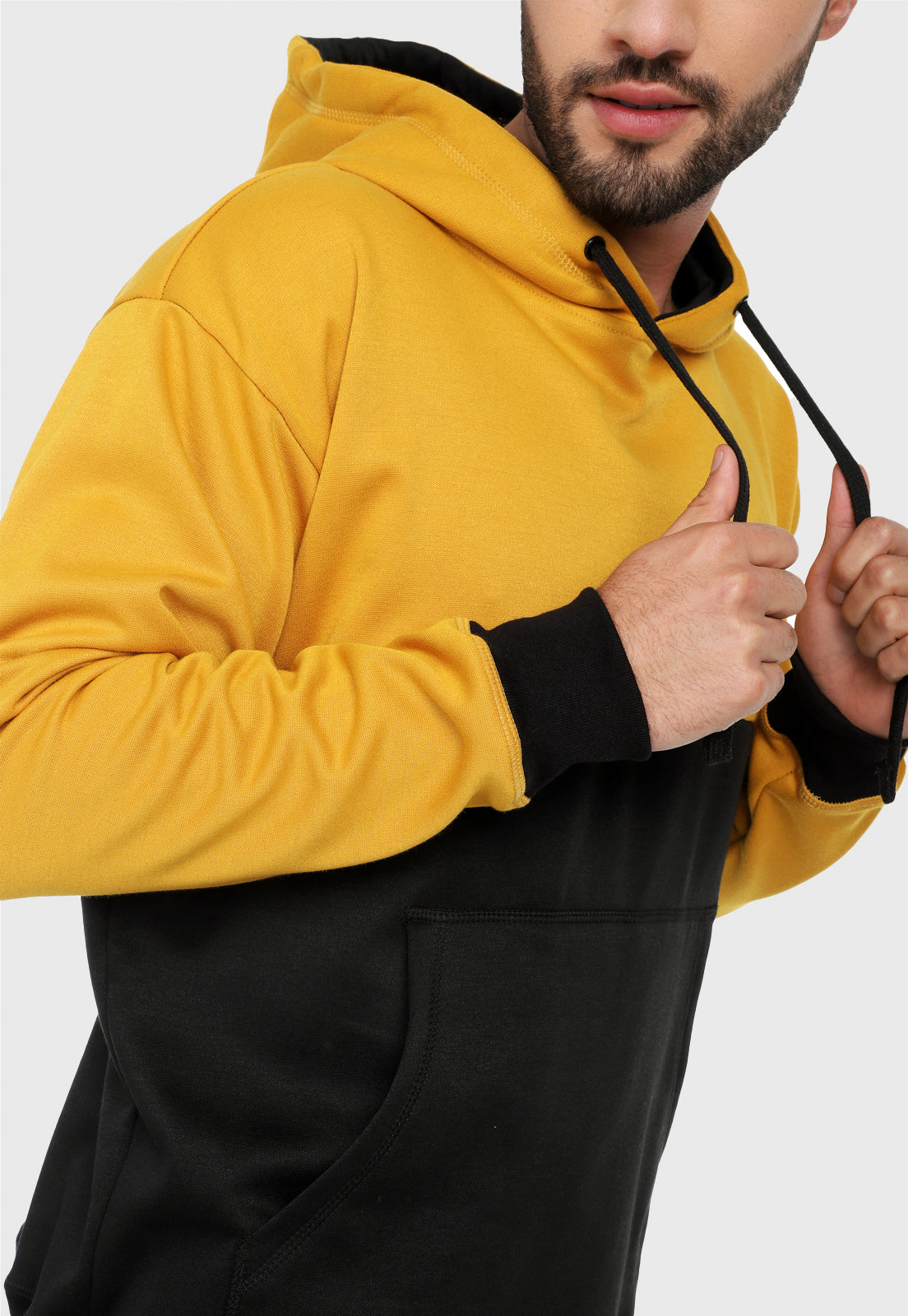 Detalle de hombre adulto vistiendo la sudadera para hombre conjunto buzo hoodie Mostaza y Negro Corte Inglés con pantalón de sudadera negro.