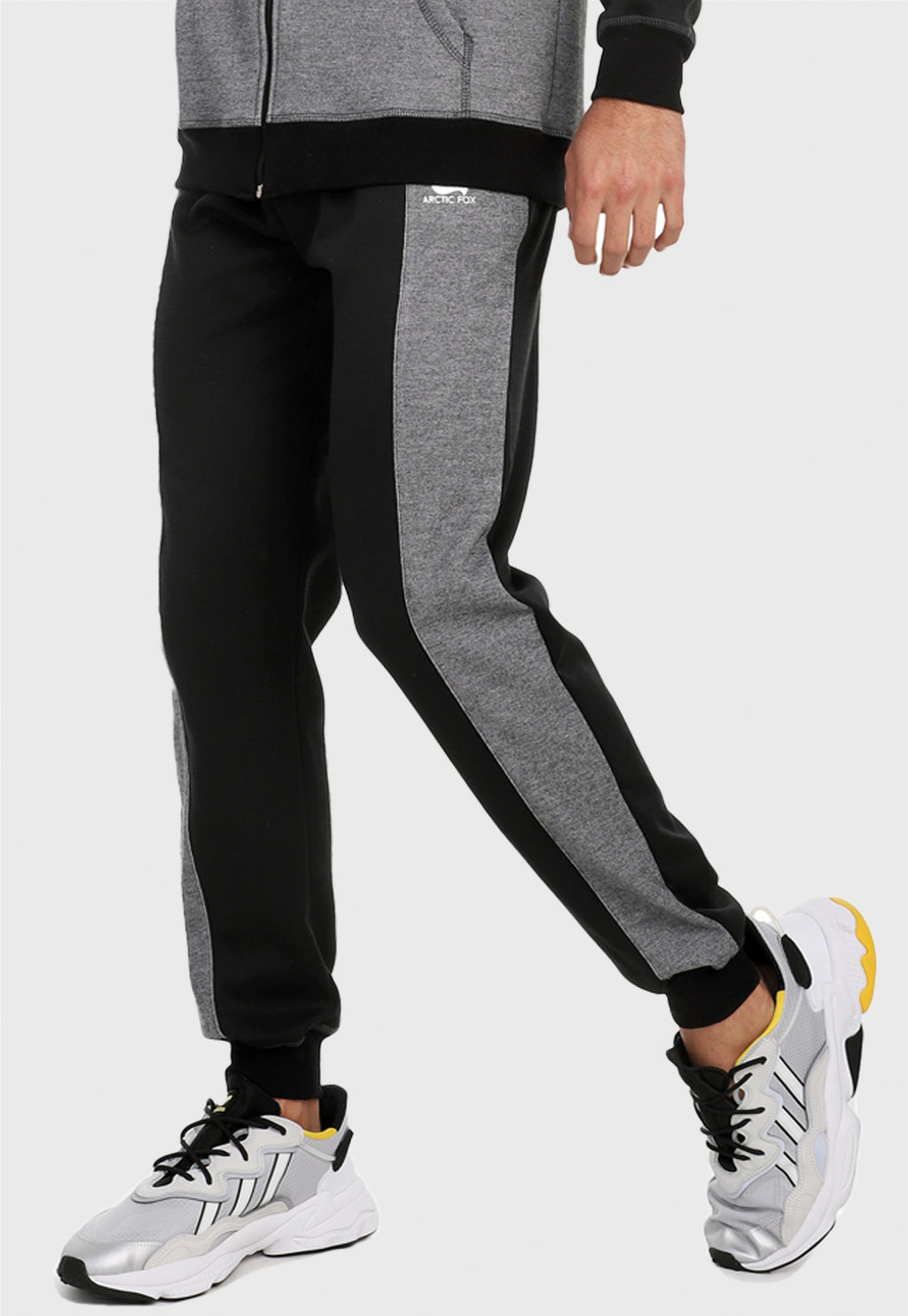 Hombre vistiendo el pantalón jogger para hombre negro con franja gris.
