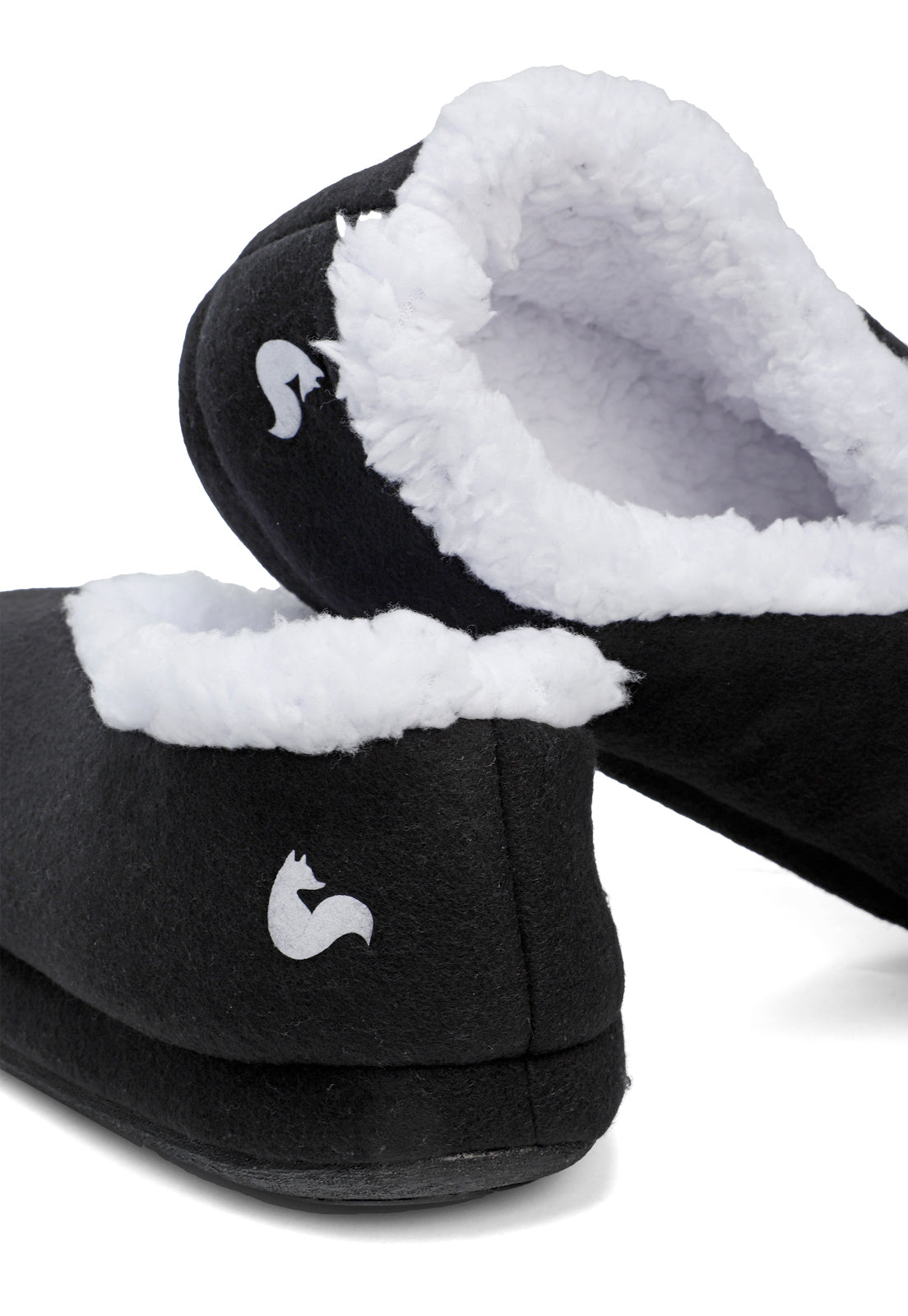 vista de cerca del peluche suave de las pantuflas negras de arctic fox