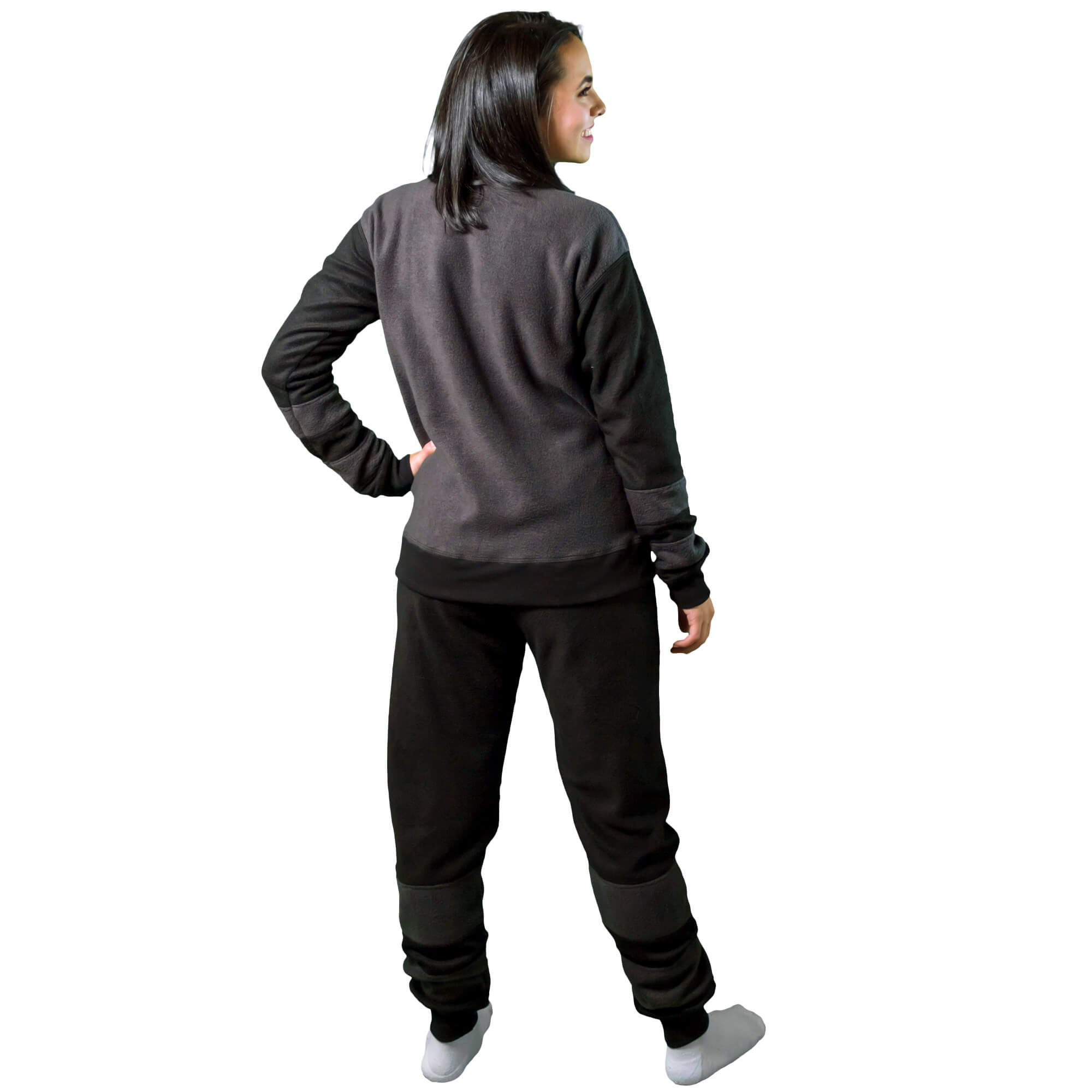 Mujer de espalda vistiendo la Pijama térmica Mapache Negro con Gris, tiene cortes en el pantalon y las mangas como si fueran la cola del mapache diseño de Arctic Fox Colombia