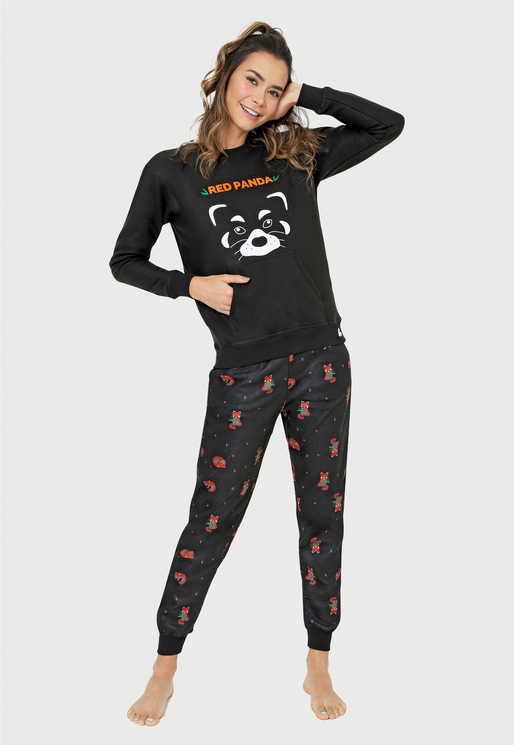 jovencita con la mano en la cara sonriendo con una pijama de panda rojo