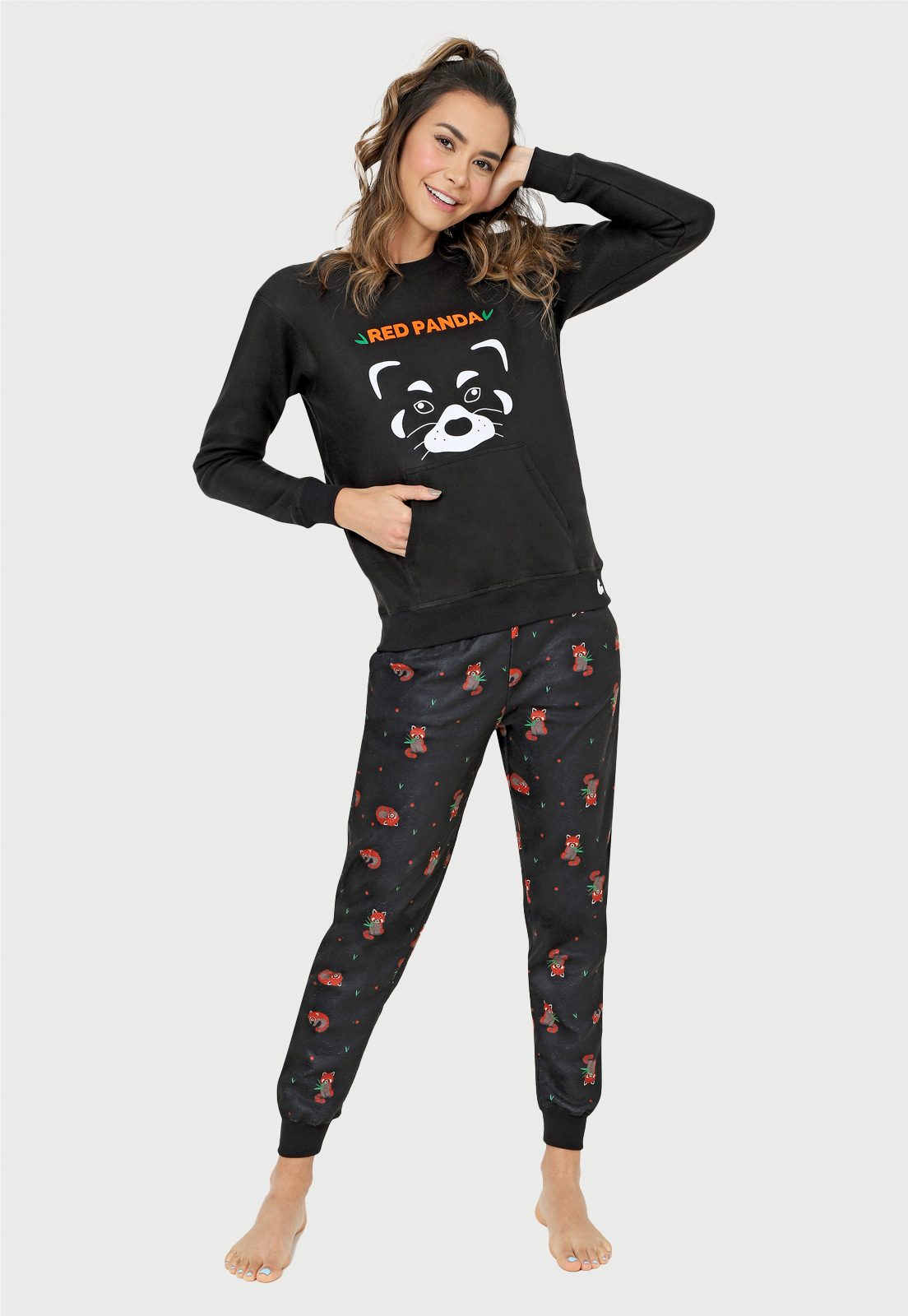 jovencita con la mano en la cara sonriendo con una pijama de panda rojo