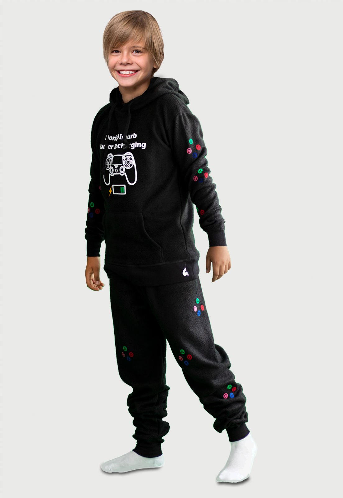 Niño vistiendo la Pijama para Niño Negra referencia Gamer Play con un control de gamer y el icono de batería cargando estampado en el pecho, en las mangas de pantalón y buzo van estampados los comando de juego en diferentes colores, diseño de Arctic Fox Colombia