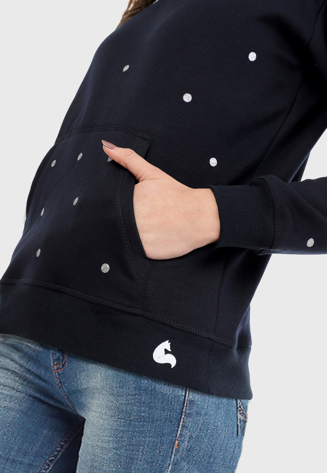 Detalle de Mujer vistiendo el Buzo Azul Navi para mujer estampado con puntos plateados y pantalón de sudadera gris.