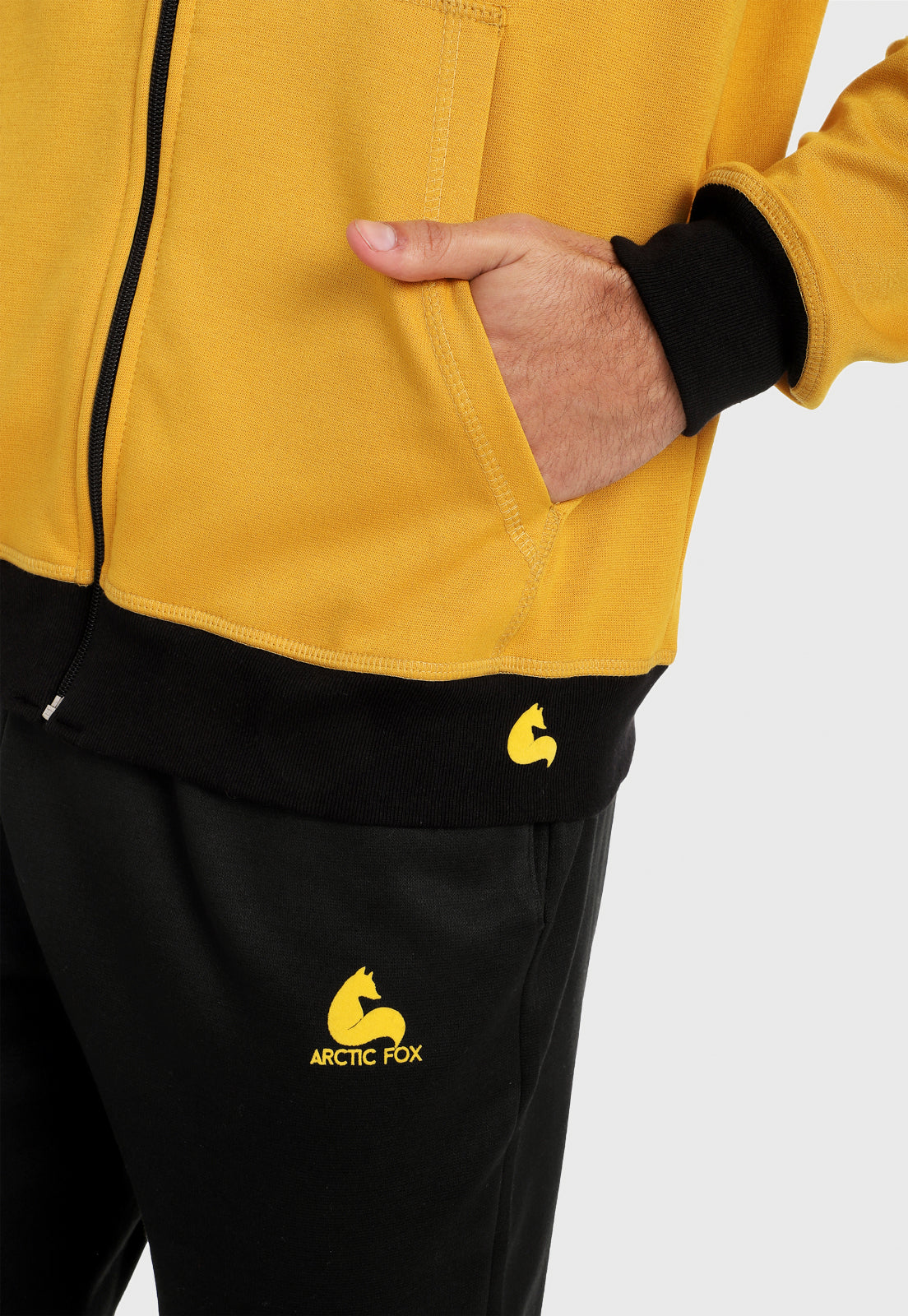 Detalle en bolsillo de hombre vistiendo la chaqueta hoodie mostaza para hombre con capota forrada al interior negra.