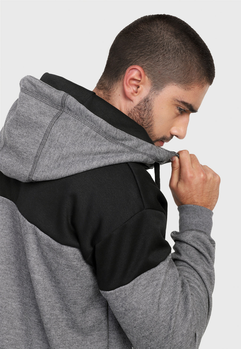 Detalle en capota de hombre vistiendo la chaqueta hoodie negra y gris para hombre en algodón perchado corte americano.