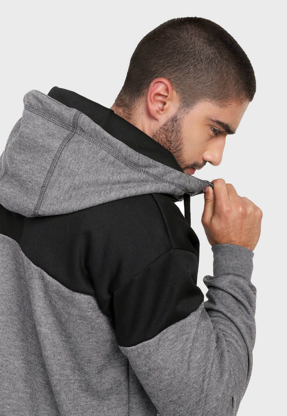 Detalle en capota de hombre vistiendo la chaqueta hoodie negra y gris para hombre en algodón perchado corte americano.