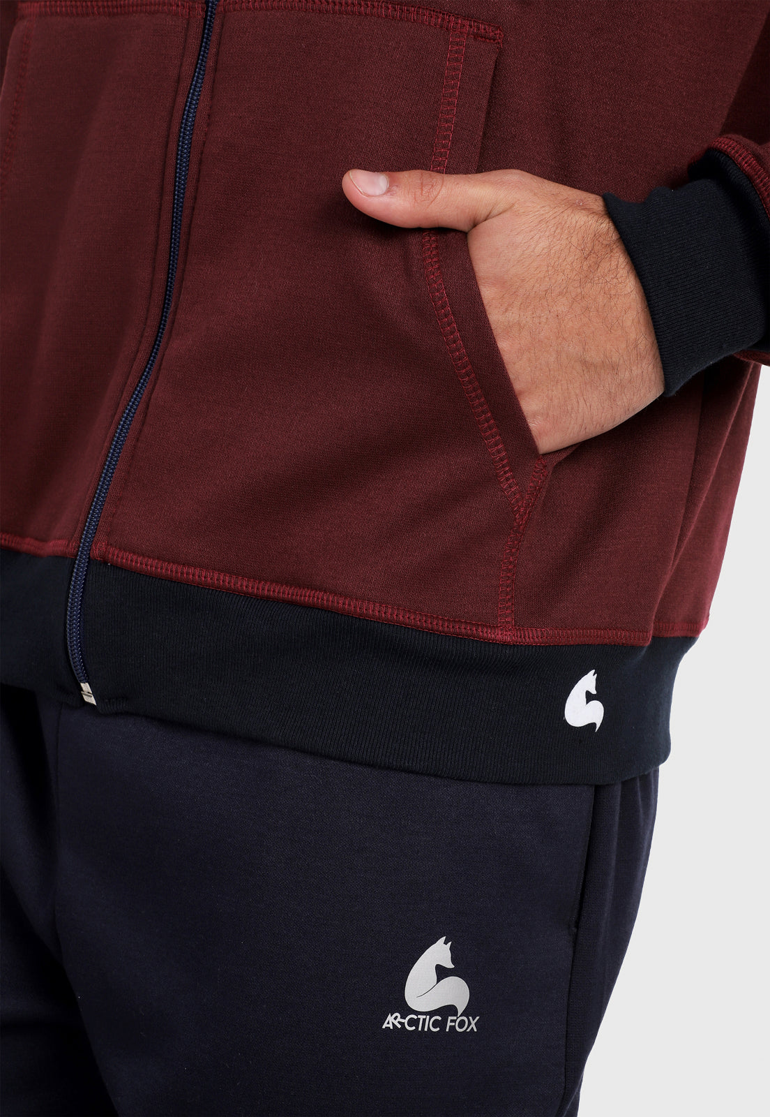 Detalle en bolsillo de hombre vistiendo la chaqueta hoodie vinotinto para hombre con capota forrada en azul.