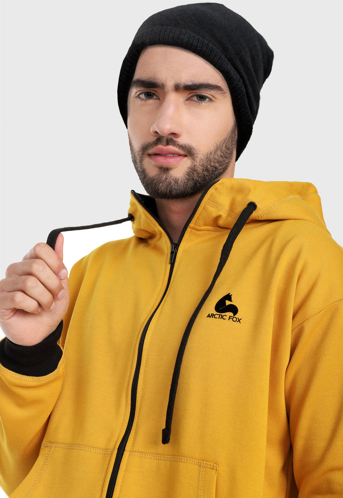 Detalle en capota de hombre vistiendo la chaqueta hoodie mostaza para hombre con capota forrada al interior negra.