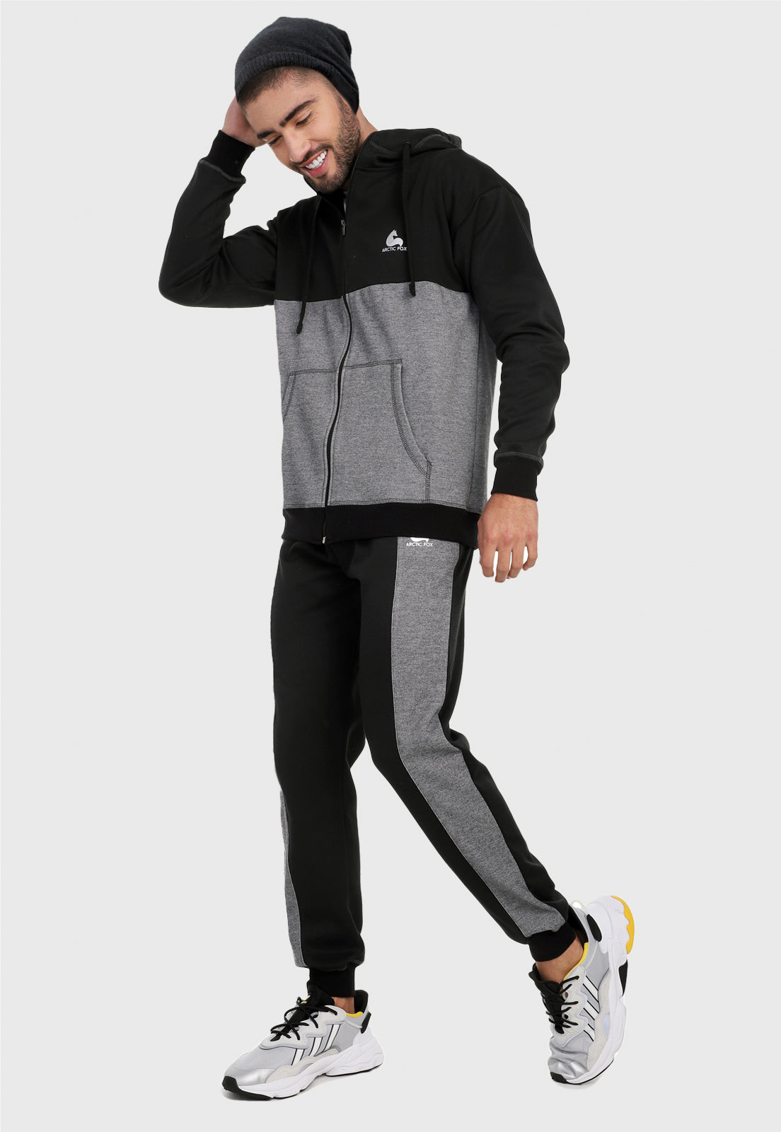Hombre adulto vistiendo la sudadera para hombre conjunto chaqueta hoodie Negro y Gris con pantalón de sudadera negro y corte gris.