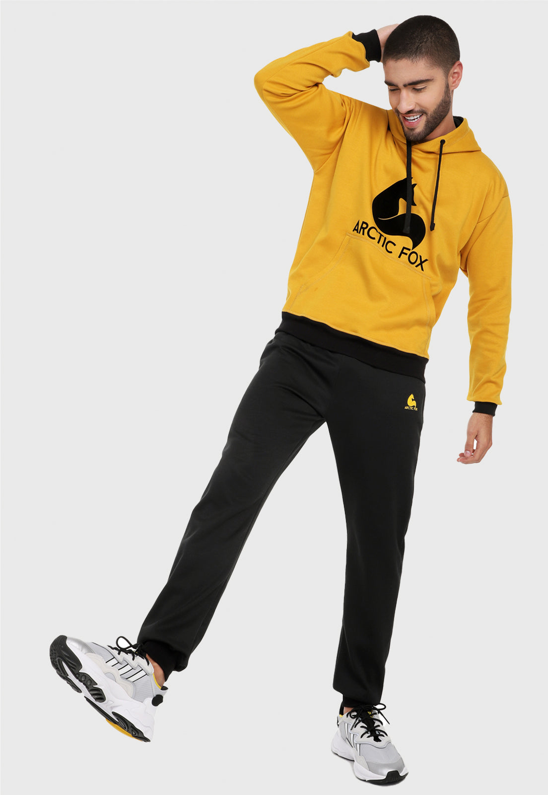 Hombre adulto vistiendo la sudadera para hombre conjunto buzo hoodie Mostaza y Negro con pantalón de sudadera negro.