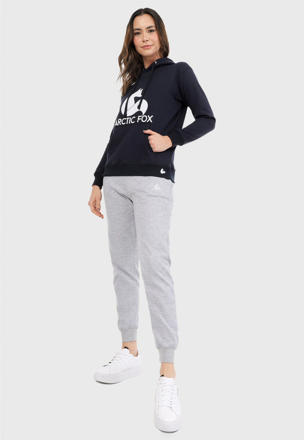 Mujer vistiendo la sudadera para mujer conjunto buzo hoodie azul navy y pantalón de sudadera gris jaspe.