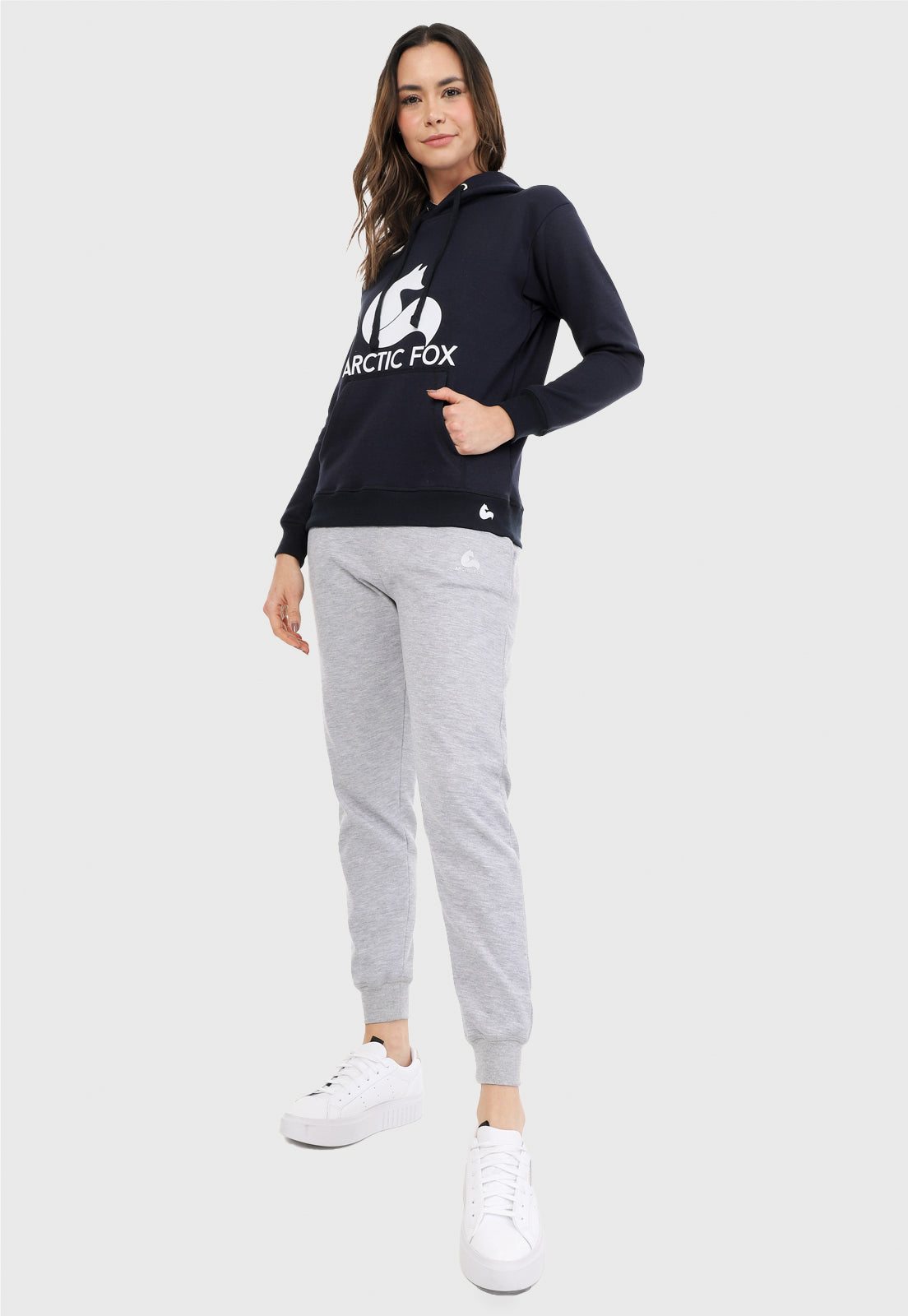 Mujer vistiendo la sudadera para mujer conjunto buzo hoodie azul navy y pantalón de sudadera gris jaspe.
