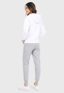 Mujer de espalda vistiendo la sudadera para mujer conjunto chaqueta hoodie blanco y gris con corazón brillante y pantalón de sudadera gris.