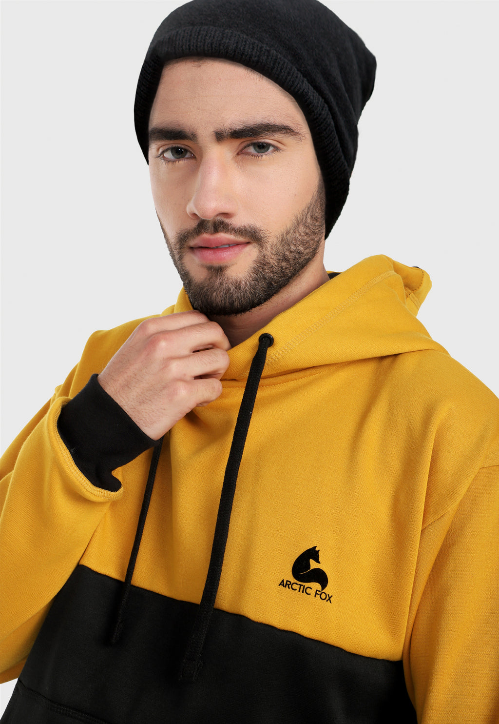 Detalle de hombre adulto vistiendo la sudadera para hombre conjunto buzo hoodie Mostaza y Negro Corte Inglés con pantalón de sudadera negro.