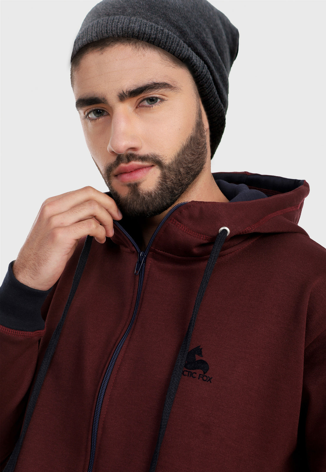 Detalle en cuello de hombre vistiendo la chaqueta hoodie vinotinto para hombre con capota forrada en azul.